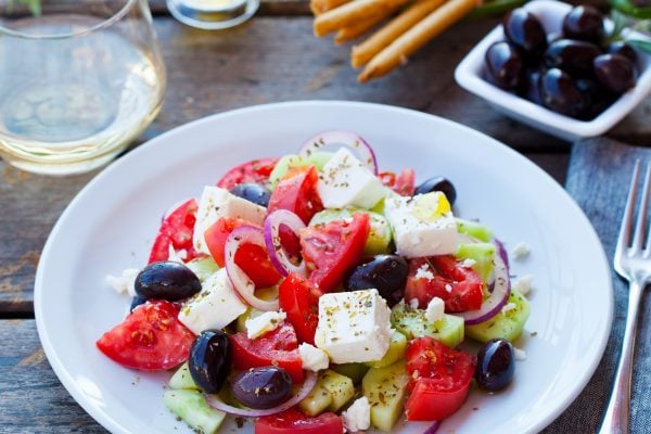 Greek salad. Fresh vegetables, feta cheese and black olives with white wine.